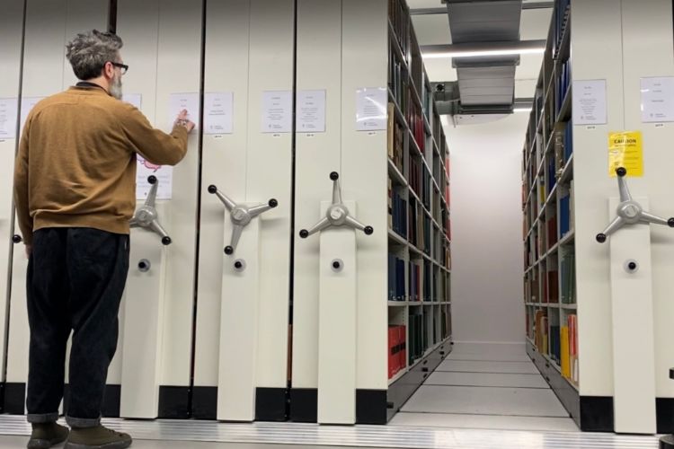 Staff using the shelving inside Walter Bower House Library